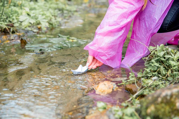 Mujer con botas de goma y un impermeable caminando bajo la lluvia — Foto de Stock