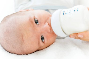 Genç Anne bebeğini bir şişe süt formülü ile besleme