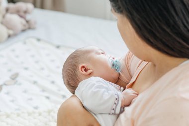 Genç Anne kucağında yeni doğan bir bebek tutan