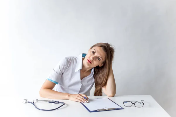 Retrato de alegre médico sonriente en uniforme sobre fondo gris — Foto de Stock