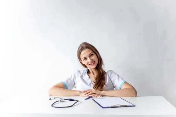 Retrato de alegre médico sonriente en uniforme sobre fondo gris — Foto de Stock