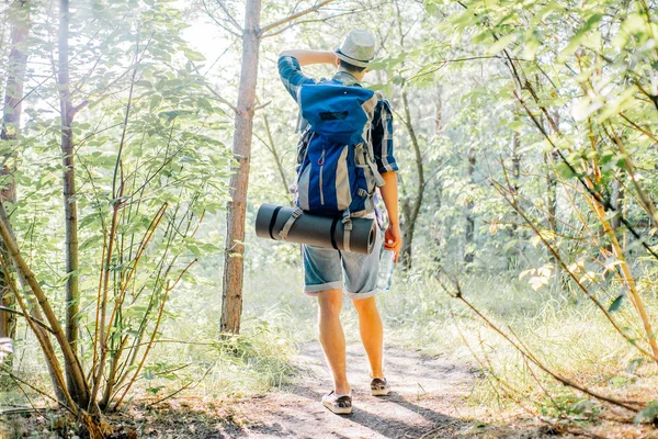 Jovem viajante cara caminhadas com mochila na natureza — Fotografia de Stock