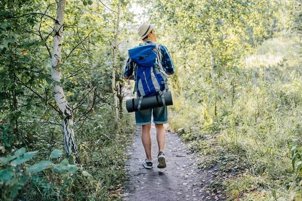 Jovem viajante cara caminhadas com mochila na natureza — Fotografia de Stock