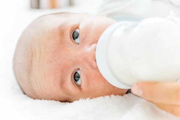 Madre che alimenta il suo bambino con una formula di latte da una bottiglia — Foto Stock