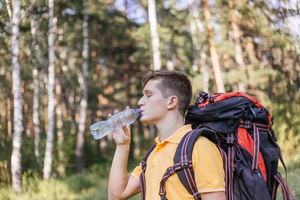 Uzun yürüyüşe çıkan kimse turist adam içme suyu bir şişe olduğunu — Stok fotoğraf