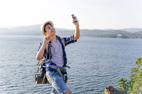 Guapo sonriente excursionista chico está tomando una foto selfie — Foto de Stock