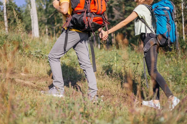 Couple of tourists with backpacks hiking in a forest — Stock Photo, Image