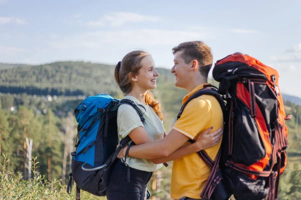 Couple of tourists with backpacks hiking up a mountain — Stock Photo, Image