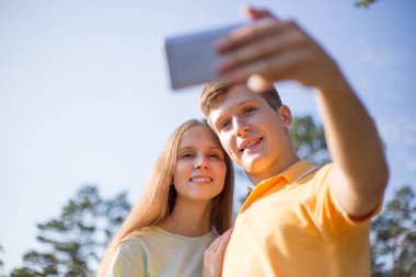 İki yürüyüşçü dağın tepesinde selfie çekiyor.