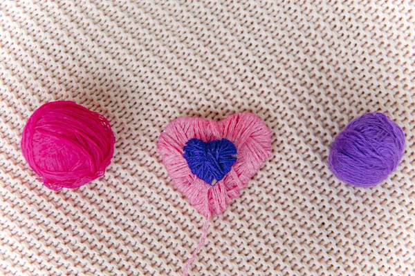 Un cuore rosa lavorato a maglia con fili di lana — Foto Stock