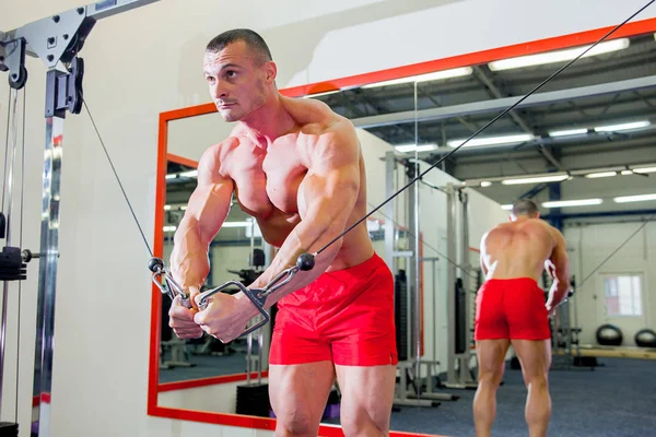 Culturista masculino haciendo ejercicios en un gimnasio —  Fotos de Stock