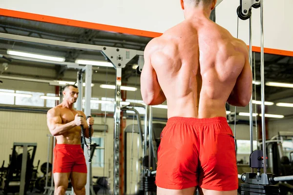 Fisiculturista masculino fazendo exercícios em um ginásio — Fotografia de Stock