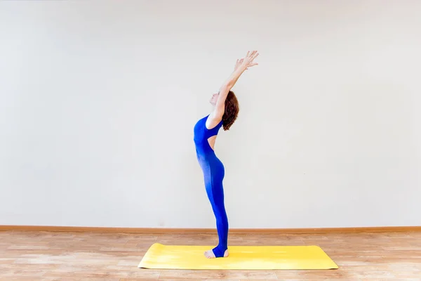 Uma mulher praticando exercícios de ioga em casa — Fotografia de Stock