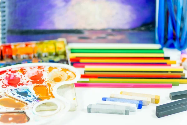 Work space on a table with pencils and paintbrushes — Stock Photo, Image