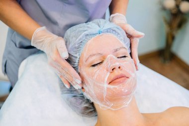 Genç güzel kadının yüz maskesi yordamı