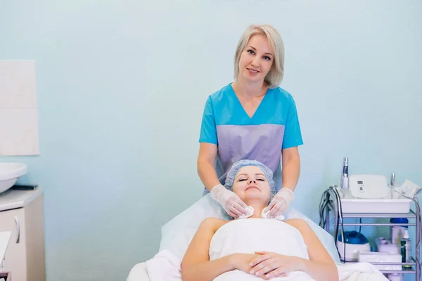 Young pretty woman enjoying face massage procedure