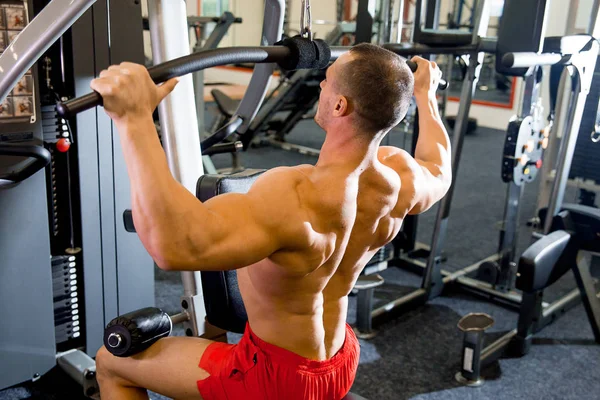 Fisiculturista masculino fazendo exercícios em um ginásio — Fotografia de Stock