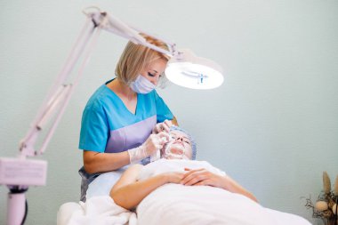 Genç güzel kadının yüz maskesi yordamı