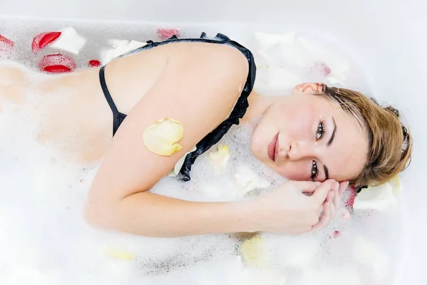 Νεαρή γυναίκα είναι χαλαρώνοντας σε μια μπανιέρα — Φωτογραφία Αρχείου