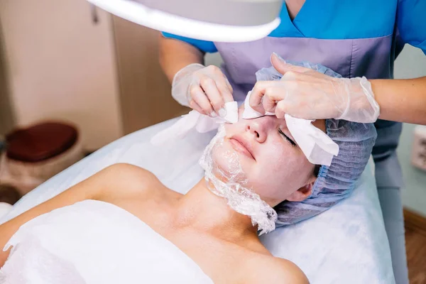 Young pretty woman enjoying a facial mask procedure — Stock Photo, Image