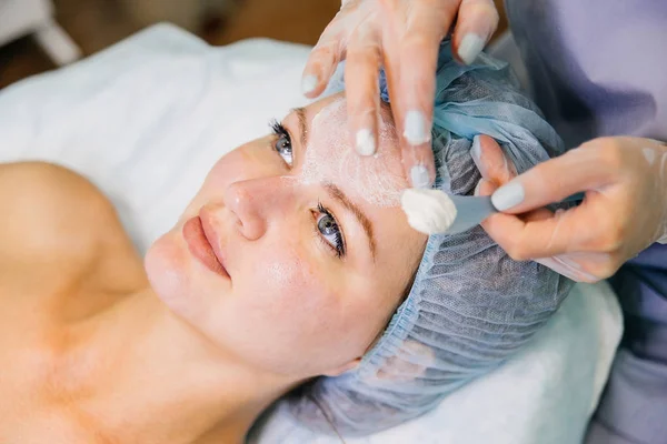 Giovane bella donna godendo di una procedura maschera facciale — Foto Stock