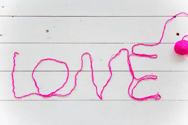 Miłość słowo z nici bawełniane kolorowe z przędz dziewiarskich — Zdjęcie stockowe