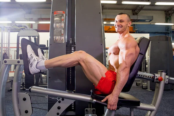 Fisiculturista masculino fazendo exercícios em um ginásio — Fotografia de Stock