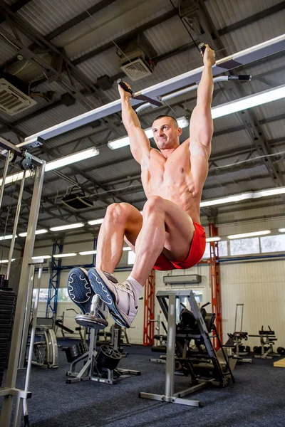Fisiculturista masculino fazendo exercícios em um ginásio — Fotografia de Stock
