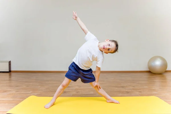 Ein kleiner Junge praktiziert Yoga zu Hause — Stockfoto