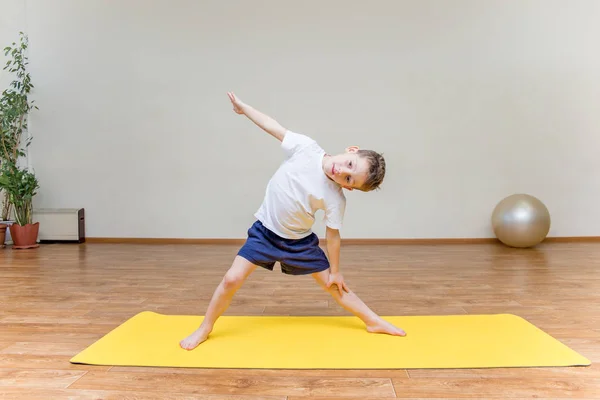 Ein kleiner Junge praktiziert Yoga zu Hause — Stockfoto