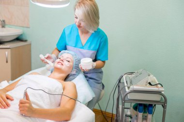 Genç güzel kadının yüz maskesi yordamı