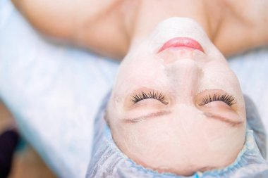 Genç güzel kadının yüz maskesi yordamı
