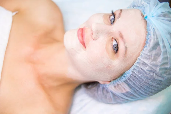 Giovane bella donna godendo di una procedura maschera facciale — Foto Stock