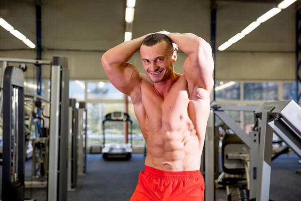 Fisiculturista masculino fazendo exercícios em um ginásio — Fotografia de Stock