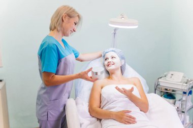 Genç güzel kadının yüz maskesi yordamı