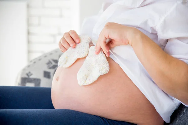 Glad gravid kvinna att välja babykläder för hennes baby — Stockfoto