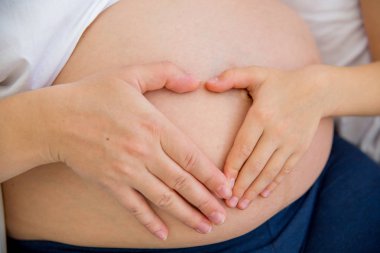 mutlu gülümseyen hamile anne kızıyla birlikte evde sarılma