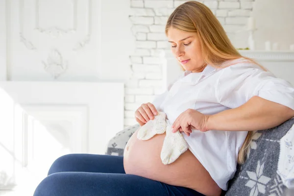 Glad gravid kvinna att välja babykläder för hennes baby — Stockfoto