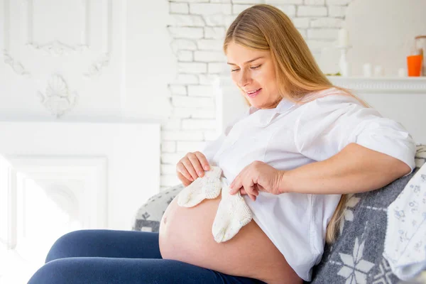 Glad gravid kvinna att välja babykläder för hennes baby — Stockfoto