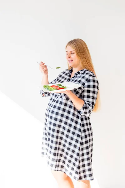 Jovem grávida comendo salada de legumes frescos em casa — Fotografia de Stock