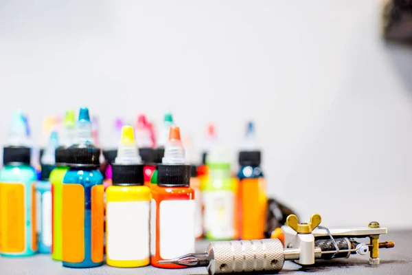 Tattoo apparatuur machine en kleurrijke inkt in een workshop — Stockfoto