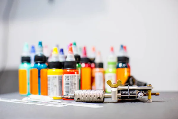 Tattoo apparatuur machine en kleurrijke inkt in een workshop — Stockfoto