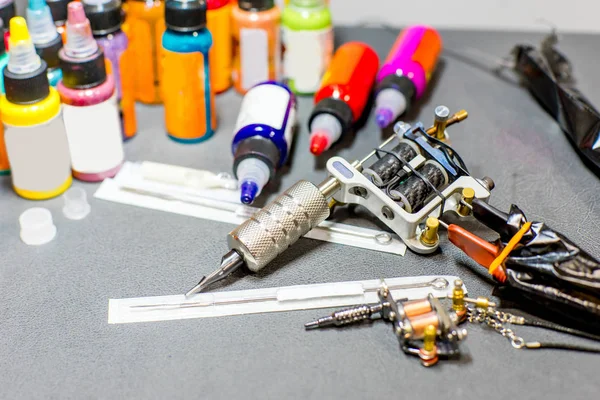 Máquina de equipamentos de tatuagem e tinta colorida em uma oficina — Fotografia de Stock