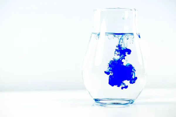 Una gota de pintura en un frasco de agua — Foto de Stock