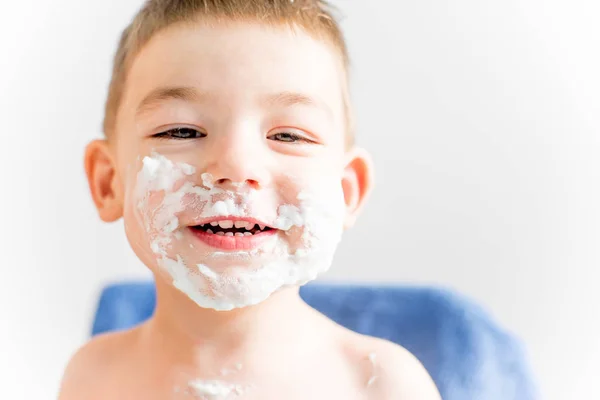 little boy face is covered in shaving foam