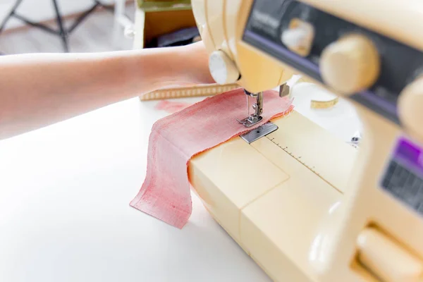 Manos femeninas están utilizando una máquina de coser — Foto de Stock