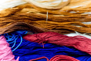 beyaz bir tablo üzerinde renkli dikiş ipliği