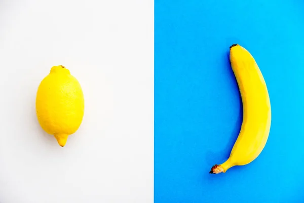 Una banana e un limone su sfondo colorato — Foto Stock