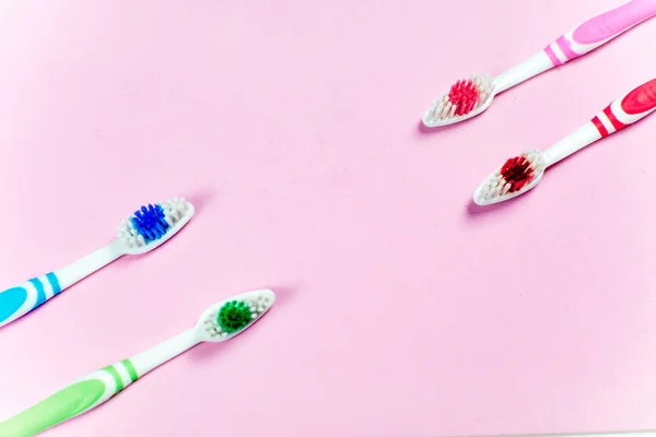 Escovas de dentes e uma pasta de dentes em um fundo colorido — Fotografia de Stock