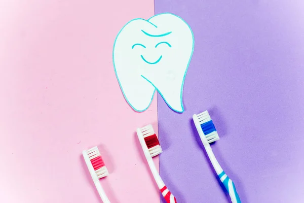 Brosses à dents et un dentifrice sur un fond coloré — Photo